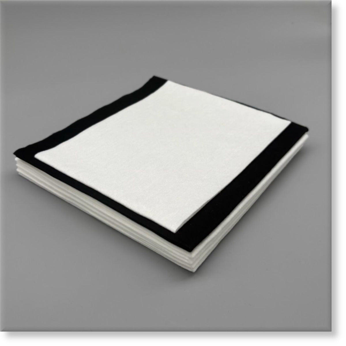 Tunika Disposable Salon Towels Image showing a mixed stack of Black and White sample towels in various sizes for a Sample Pack