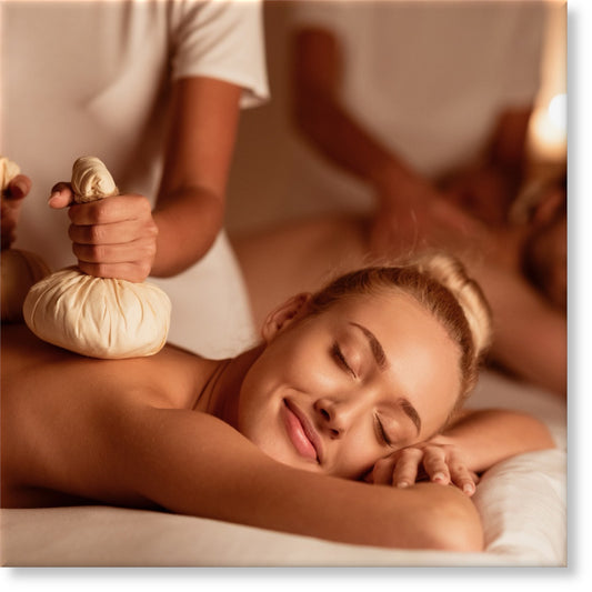 Couple Enjoying Herbal Massage. Relaxed Husband And Wife At Exotic Spa Resort, Lying With Eyes Closed Receiving Thai Massage With Aromatic Bags. Body Beauty Treatment, Relaxation And Wellness